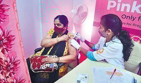 A health worker administers booster dose to a beneficiary at Malleswaram in Bengaluru on Monday. (Photo | Shriram BN/EPS)