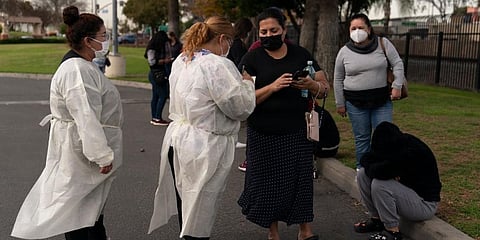 Two healthcare workers help residents check in at a mobile COVID-19 testing site in Paramount. (Photo | AP)