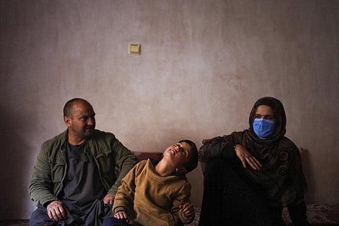Sanam, a bacha posh, a girl living as a boy, sits next to her mother and father during an interview in their house, in Kabul, Afghanistan, Dec. 7, 2021. (Photo | AP)