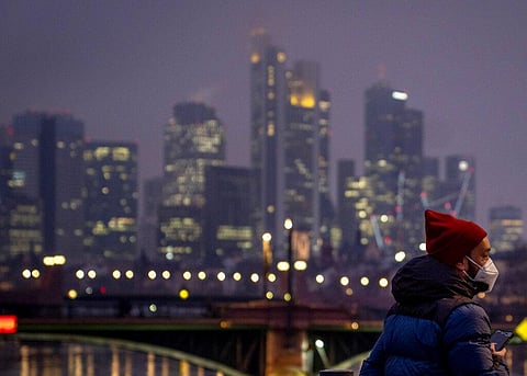 A man wearing a face mask stands near the buildings of the banking district in Frankfurt, Germany, Thursday, Jan. 13, 2022. (Photo | AP)