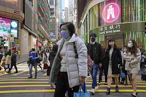 People walk across a street in Hong Kong, Tuesday, Jan. 11, 2022. (Photo | AP)