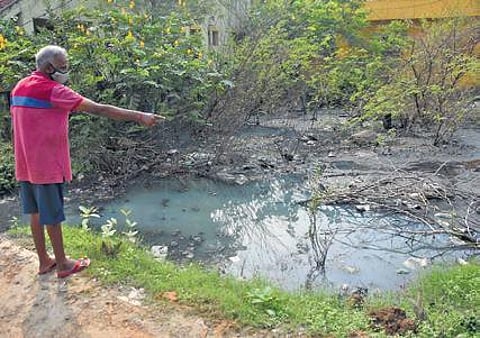 A resident of Subam Nagar points at the water mixed with sewage in his locality. (Photo| Ashwin Prasath, EPS)