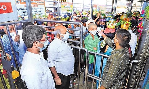 A temple staffer conducts thermal screening of devotees at Sri Raja Rajeshwara Swamy temple in Vemulawada of Rajanna-Sircilla district on Wednesday