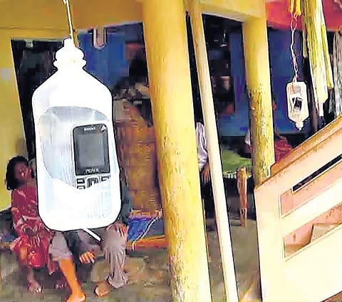 A family in Mukundapuram village of Meliyaputti mandal keeping their mobiles in empty medical saline bottles for getting network I express