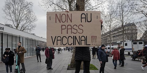 Demonstrator holds a placard that reads 'No to vaccine pass' in opposition to vaccine pass and vaccinations to protect against COVID-19 during a rally in Paris, Jan. 22, 2022.(Photo | AP)
