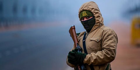 A woman security personnel stands guard on a cold winter morning at Rajpath in New Delhi. (Photo | EPS)