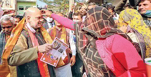 Shah during door-to-door election campaign at Satoha village in UP’s Mathura district on Thursday. (Photo | PTI)