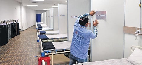 A worker demarcates the Omicron ward inside a dedicated Covid-19 facility at the Commonwealth Games Village in New Delhi. (File Photo | Shekhar Yadav)