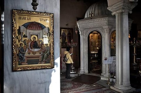 A Greek Orthodox Christian believer is seen inside a church in Thessaloniki, northern Greece. (Photo | AFP)