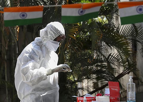 A health worker checks nasal swab samples at a COVID-19 testing center in Hyderabad. (Photo | AP)