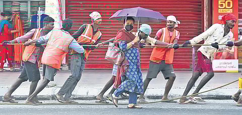 Migrant workers of Cochin Smart Mission Limited, without wearing masks, pull cables at High Court junction | A Sanesh