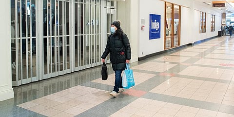 A woman walks by a closed store in a mall in Canada. (Photo | AP)