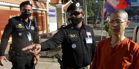 Court securities direct Cambodian-American lawyer Theary Seng (R) dressed in a prison-style orange outfit, to the entrance of Phnom Penh Municipal Court in Phnom Penh, Cambodia. (Photo | AP)