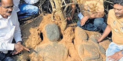 Archaeologists and history enthusiasts remove the bushes grown on the sculptures