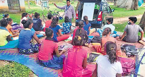 Rajesh Kumar takes classes using a board fixed at the back of his vehicle. (Photo | EPS)