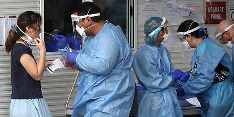 Health workers attend at a COVID-19 testing site in Brisbane, Australia. (Photo | AP)