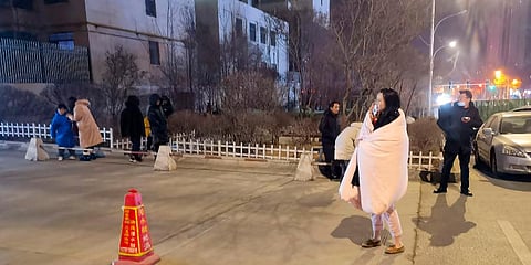In this photo released by China's Xinhua News Agency, people stand on the street after an earthquake in Xining in northwestern China's Qinghai Province, early Saturday, Jan. 8, 2022. (Photo | AP)