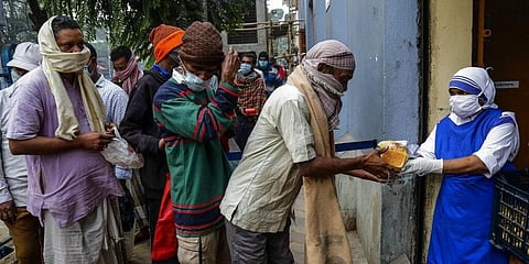 Nuns of Missionaries of Charity, the order founded by Saint Teresa, distribute food to the poor and needy its headquarter in Kolkata. (Photo | AP)