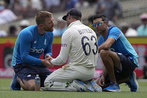 England's Jos Buttler, center, is treated for an injury in a break in play during the second day of their Ashes cricket test match against Australia in Sydney. (Photo | AP)