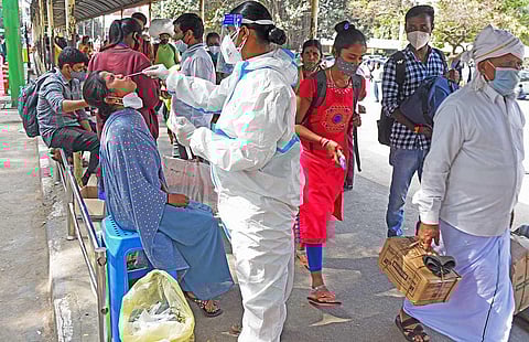 A health worker collects swab samples from passengers at a bus stand in Bengaluru (File Photo | Vinod Kumar T, EPS)