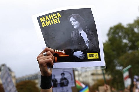A protester shows a portrait of Mahsa Amini during a demonstration to support Iranian protesters standing up to their leadership over the death of a young woman in police custody. (Photo | AP)