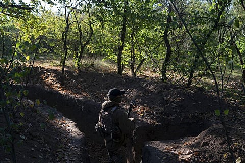 A Ukrainian serviceman checks the trenches dug by Russian soldiers in a retaken area in Kherson region, Ukraine. (Photo | AP)