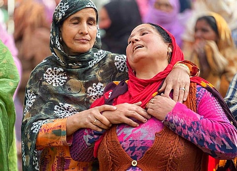 A woman mourns the killing of her brother-in-law Puran Krishan Bhat, who is from the minority community of Kashmiri Hindus, outside his home in in southern Shopian district. (Photo |AP)