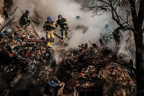 Ukrainian firefighters works on a destroyed building after a drone attack in Kyiv on October 17, 2022, amid the Russian invasion of Ukraine. (Photo | AFP)
