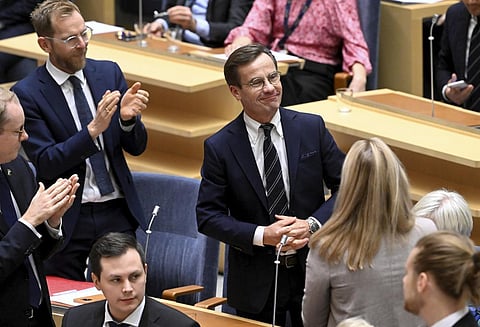 Moderate Party leader Ulf Kristersson, center, smiles after being elected as Sweden's new prime minister at the Parliament in Stockholm, Monday Oct. 17, 2022.