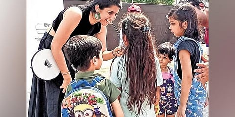 Alma interacting with the children; (below) a child painting at the event