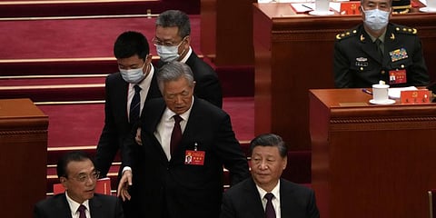 Former President Hu Jintao walks past Chinese President Xi Jinping, right, and Premier Li Keqiang during the closing ceremony of the 20th National Congress. (Photo | PTI)