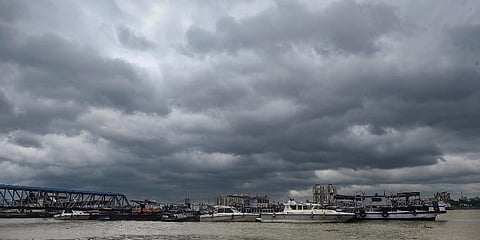 Dark clouds hover in the skies above the boats parked on the bank of Ganga river. (Photo | PTI)