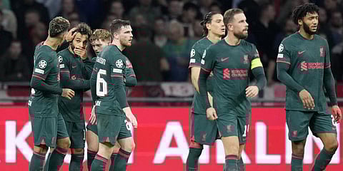 Liverpool's Mohamed Salah, 2nd left, is congratulated by his teammates after scoring the opening goal during the Champions League group A match against Ajax.(Photo | AP)