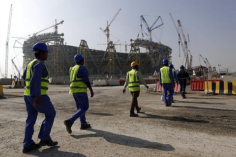 Workers walk to the Lusail Stadium, one of the 2022 World Cup stadiums, in Lusail, Qatar, Dec. 20, 2019. (File Photo | AP)