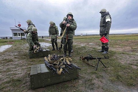 Recruits prepare their weapons as an instructor looks at them during military training at a firing range in Volgograd region, Russia, Oct. 27, 2022. (Photo | AP)