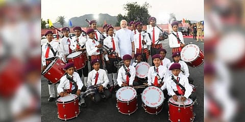 PM Narendra Modi with a musical band of tribal children from the Ambaji town of Banaskantha district, Gujarat (Photo | ANI)