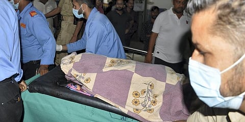 Police personnel shift body of Jammu and Kashmir's Director General (Prisons) Hemant K. Lohia to a hospital, in Jammu district. (Photo |PTI)