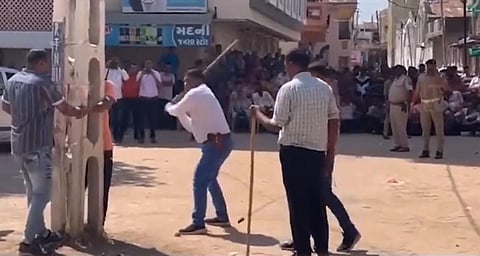 Cops were caught on camera allegedly publicly flogging a few Muslim community members accused of hurling stones at garba dance participants in Kheda district, Gujarat. (Video screengrab)
