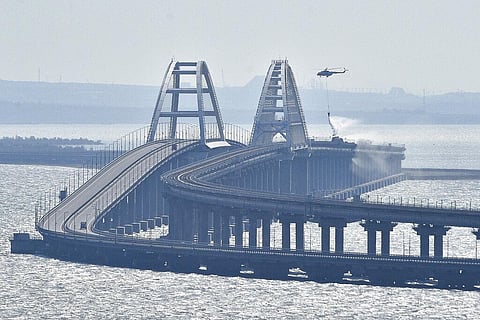 A helicopter drops water to stop fire on Crimean Bridge connecting Russian mainland and Crimean peninsula over the Kerch Strait, in Kerch, Saturday, Oct. 8, 2022. (Photo | AP)