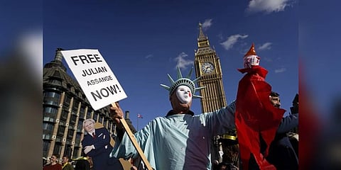 A supporter of WikiLeaks founder Julian Assange holds a placard outside of the Houses of Parliament, in London. (Photo | AFP)