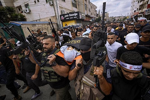 Armed Palestinians carry the body of Mahmoud Al-Sous, covered with a flag of the Islamic Jihad militant group during his funeral in the West Bank town of Jenin, Saturday, Oct. 8, 2022. (Photo | AP)