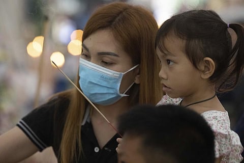 Paweenuch Supolwong, 3, the only child to emerge unscathed from the mass killing attack at the day care center, and her mother join a Buddhist ceremony inside Wat Rat Samakee temple. (Photo | AP)