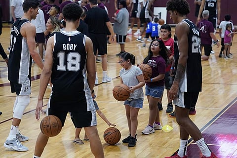 Members of the San Antonio Spurs NBA basketball team work with students from Robb Elementary School during a visit, Saturday, Oct. 8, 2022, in Uvalde, Texas. (Photo | AP)