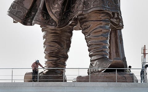 Workers near the 108 feet statue of Nadaprabhu Kempegowda at Kempegowda International Airport in Bengaluru. (Photo | PTI)