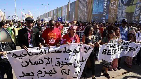 The sister of jailed Egyptian activist Alaa Abdel Fattah, Sanaa Seif (fourth from left), was at the front of the protest for climate justice and human rights. (Photo | AFP)