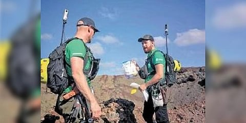 Astronaut Alexander Gerst collecting a sample of volcanic rock in the middle of Los Volcanes Natural Park.