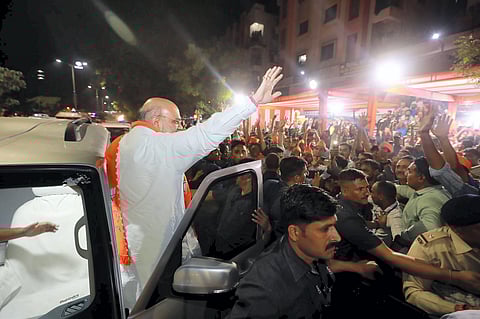 Union Home Minister Amit Shah waves at supporters upon his arrival to meet BJP workers, ahead of Gujarat assembly elections, in Ahmedabad. (Photo | PTI)