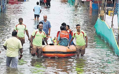 Fire and Rescue Services personnel moving residents of Om Shakthi Nagar in Mangadu in a boat to safety | Ashwin prasath
