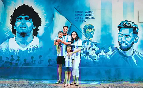 Shinith Patyam with his wife Neenupriya, daughter Saasha and son Gramsci, in front of the outer wall of his house painted with Argentina super stars Diego Maradona and Lionel Messi