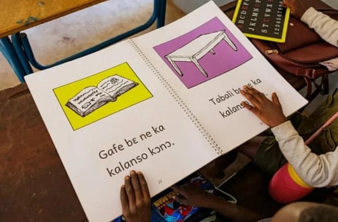 Young girls use a book to learn Bambara, one of Mali’s main national languages. (Photo | AFP)